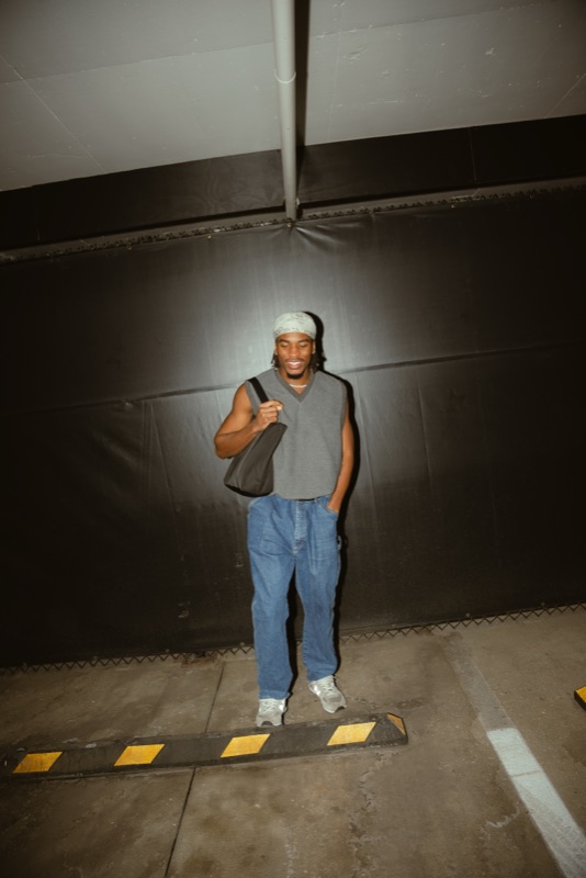 Osa Deraé standing in a parking garage with a tote bag